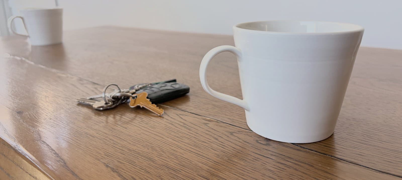 Two people living separately in the same home, in a quiet shared kitchen.